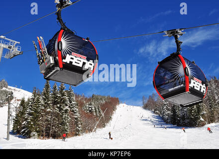 Jasna, Slovaquie - Décembre 01, 2017 : deux cabines de la téléphérique et skieurs sur la pente de la montagne Chopok côté sud sur une journée ensoleillée dans la station de ski re Banque D'Images