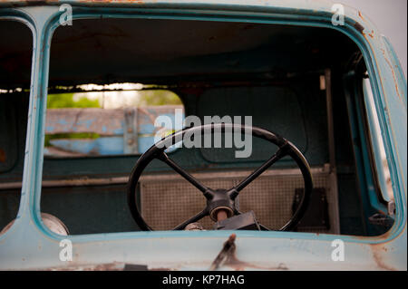 Retro noir volant à l'intérieur de vieux et abandonnés camion bleu Banque D'Images