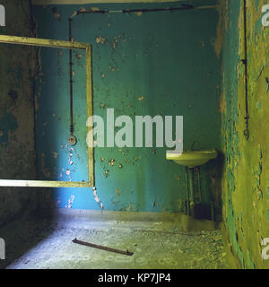 Pièce de la maison en ruines dans la zone d'exclusion de l'acide : Pripyat de murs aux couleurs claires, casse de shell, châssis de fenêtre avec des lunettes cassées, Tchernobyl, l'Ukraine. Banque D'Images