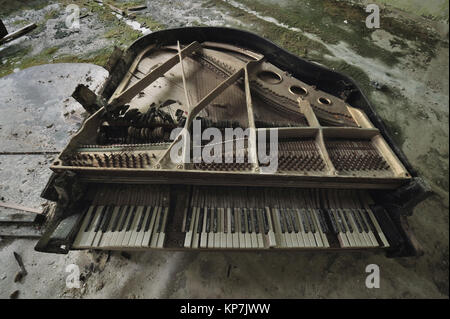 Vieux piano ruiné dans la salle de concert dans la maison de la culture, pas de Pripyat, couvre les clés sont couverts de moisissures et de brisures, Tchernobyl, l'Ukraine. Banque D'Images