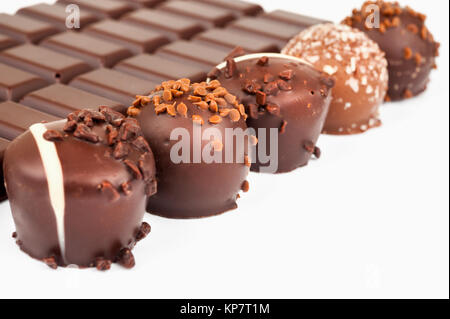 Rangée de truffes au chocolat et une barre de chocolat sur fond blanc Banque D'Images