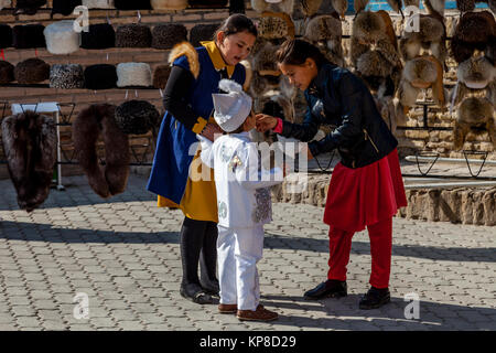 Deux Sœurs de nourrir leur petit frère de la barbe à papa dans la vieille ville de Khiva, Ouzbékistan Banque D'Images