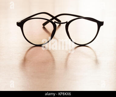 Lunettes avec réflexion sur table en bois Banque D'Images