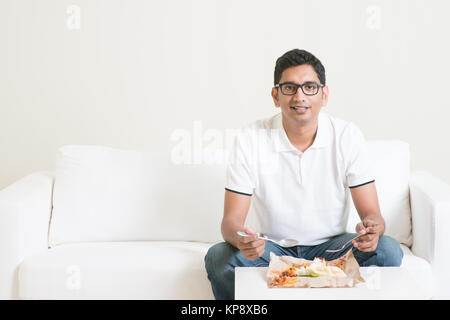 Homme seul solitaire de manger des aliments à la maison Banque D'Images