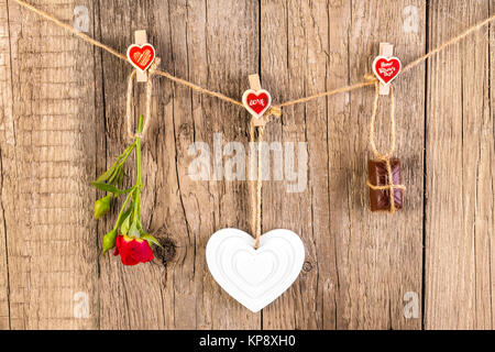 Rose rouge avec blanc forme coeur et chocolat sur sol en bois Banque D'Images