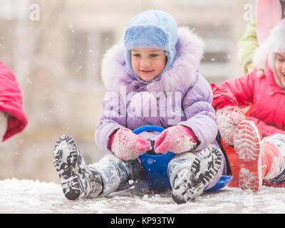 Happy little girl s'apprête à descendre la colline glacée Banque D'Images