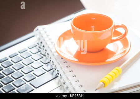 Ordinateur portable avec tasse à café et le bloc-notes sur 24 Banque D'Images