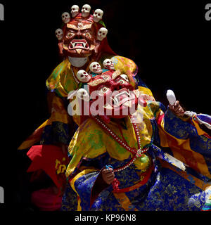 Les moines bouddhistes dans l'ancienne Mahakala rouge crânes des masques avec sur le dessus de la danse Cham rituel masque effectuer, Zanskar, Inde du Nord. Banque D'Images