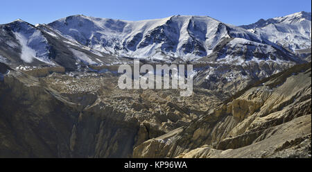 L'hiver dans les montagnes : les chaînes de montagnes sont couvertes de neige en haut, ci-dessous sont de couleur jaune et brun rocks, l'Himalaya. Banque D'Images