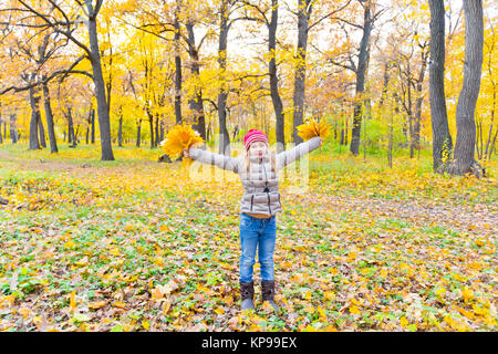 Jolie fille avec des bouquets de feuilles en automne Banque D'Images