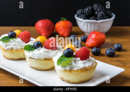 Mini cheesecakes à la Fraise et crème fouettée sur une plaque Banque D'Images