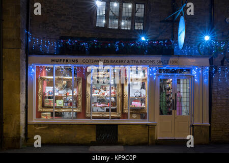 Huffkins bakery et salons de thé à la place du marché avec des décorations de Noël dans la nuit. Stow on the Wold, Cotswolds, Gloucestershire, Angleterre Banque D'Images