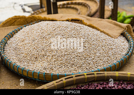 Grains d'orge dans le bac sur la table en bois à l'arrière-plan market Banque D'Images