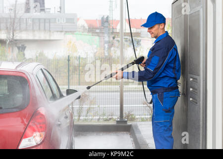 Conscrit avec jet d'eau haute pression lavage voiture Banque D'Images