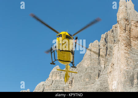 Hélicoptère jaune utilisé pour les opérations de sauvetage, sur le terrain en Dolomites, Italie. Sauvetage par hélicoptère. Vol en hélicoptère de sauvetage médical blessés sauvetage cl Banque D'Images