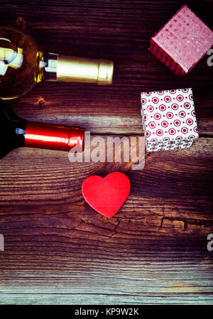 Cœur, des cadeaux et des bouteilles de vin à table. Banque D'Images