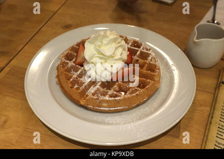 Gaufre avec de la crème chantilly, fraise et cerise Banque D'Images