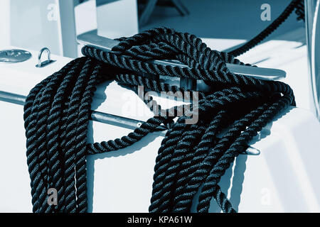 Close-up d'une corde d'amarrage avec une extrémité nouée autour d'un crochet attaché sur une jetée en bois. Amarre nautique Banque D'Images