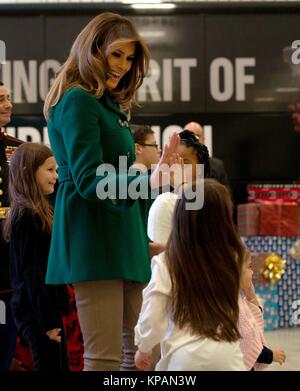 Washington, États-Unis d'Amérique. 13 Décembre, 2017. Première Dame des États-Unis Melania Trump fives élevé un enfant pendant l'assemblée annuelle de la fondation du Marine Corps Toys for Tots event at Joint Base Anacostia-Bolling Décembre 13, 2017 à Washington, DC. La Première Dame a suivi la longue tradition d'autres sapins Mesdames en aidant les enfants à faire des cartes, trié les jouets et honorer l'événement de bienfaisance. Credit : Planetpix/Alamy Live News Banque D'Images