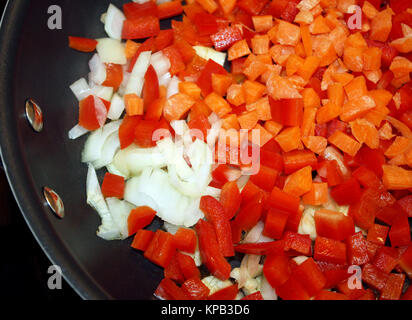 Des poivrons rouges en dés, les carottes et les oignons dans une poêle non prêt pour la friture Banque D'Images