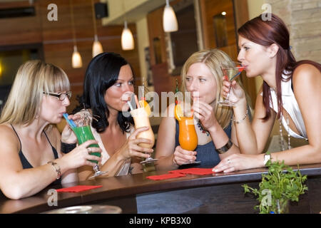 Communiqué de modèle, Vier junge Frauen mit sitzen an der Bar cocktails - quatre femmes dans un bar à cocktails Banque D'Images