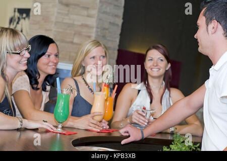 Communiqué de modèle, Junger Kellner flirtet mit vier Frauen an der Bar - barman coquets avec quatre femmes au bar Banque D'Images