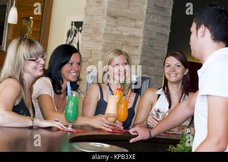 Communiqué de modèle, Junger Kellner flirtet mit vier Frauen an der Bar - barman coquets avec quatre femmes au bar Banque D'Images