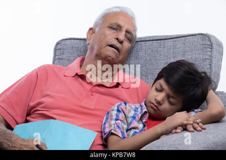 Grand-père et petit-fils de dormir sur un canapé Banque D'Images