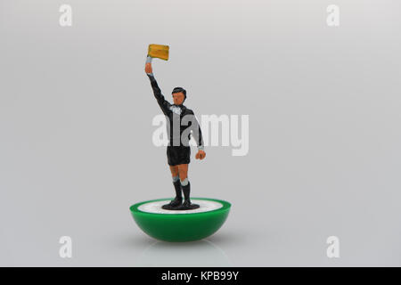 Un Subbuteo juge de ligne sur un fond blanc avec drapeau hissé. Concept possible utilisation. Banque D'Images