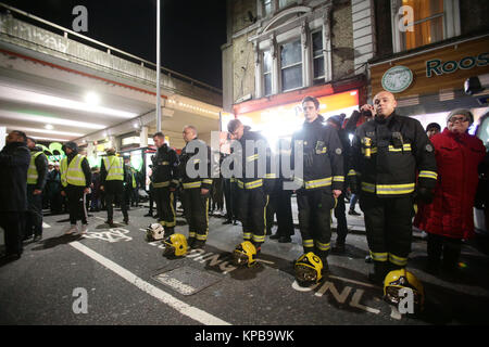 Les pompiers de rendre hommage comme les gens prennent part à une marche silencieuse pour marquer les six mois anniversaire de l'incendie de la tour de Grenfell, dans l'ouest de Londres. Banque D'Images