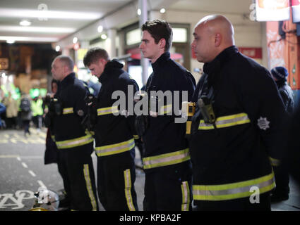 Les pompiers de rendre hommage comme les gens prennent part à une marche silencieuse pour marquer les six mois anniversaire de l'incendie de la tour de Grenfell, dans l'ouest de Londres. Banque D'Images