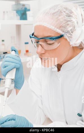 Jeune femme scientifique ou technique fonctionne avec une pipette automatique Banque D'Images