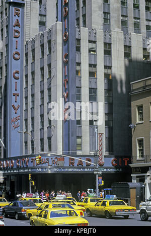 1987 TAXIS JAUNES HISTORIQUES (©GENERAL MOTORS 1985) RADIO CITY MUSIC HALL ROCKEFELLER CENTER (©RAYMOND HOOD 1939) SIXTH AVENUE MANHATTAN NEW YORK CITY ETATS-UNIS Banque D'Images