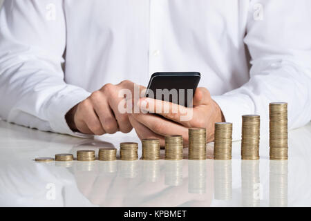 Smartphone woman Laughing At Desk Banque D'Images
