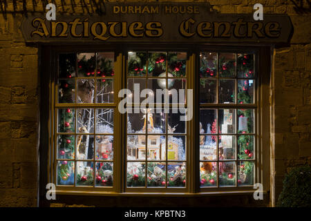 Maison centre Durham antiquités affichage de vitrine de Noël dans la nuit. Stow on the Wold, Cotswolds, Gloucestershire, Angleterre Banque D'Images