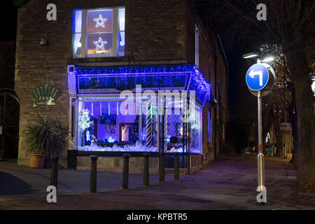 Lumières de Noël bleu et décorations de Noël dans l'avant-garde coiffeurs vitrine de Brackley, Northamptonshire, Angleterre Banque D'Images