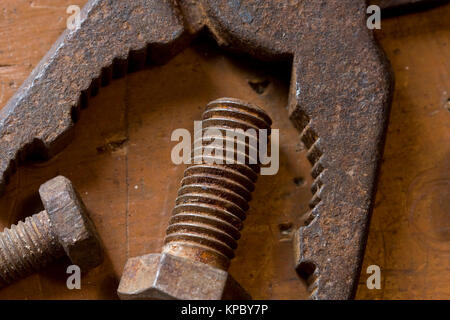 Ancienne pince rouillée et screwbolts sur l'établi Banque D'Images