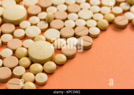 Heap of assorted capsules beige orange sur table. Banque D'Images