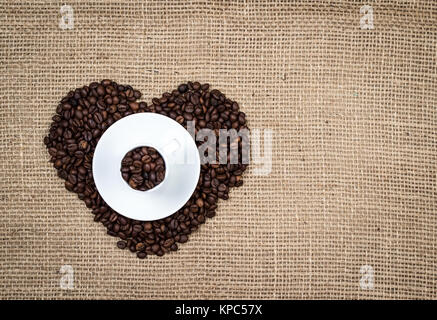 Tasse blanche sur les grains de café coeur Banque D'Images