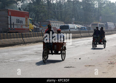 Une batterie terme rickshaw sillonnent l'autoroute près de Dhaka-Aricha Amin Bazar à Dhaka Banque D'Images