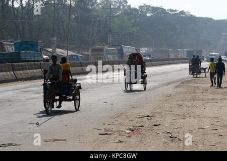 Une batterie terme rickshaw sillonnent l'autoroute près de Dhaka-Aricha Amin Bazar à Dhaka Banque D'Images