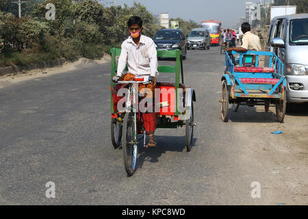 Une batterie terme rickshaw sillonnent l'autoroute près de Dhaka-Aricha Amin Bazar à Dhaka Banque D'Images