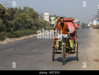 Une batterie terme rickshaw sillonnent l'autoroute près de Dhaka-Aricha Amin Bazar à Dhaka Banque D'Images