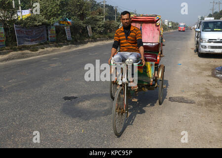 Une batterie terme rickshaw sillonnent l'autoroute près de Dhaka-Aricha Amin Bazar à Dhaka Banque D'Images