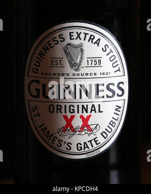 Une bouteille de Guinness Extra Stout original sur une table dans un pub. Banque D'Images