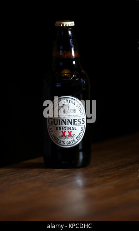 Une bouteille de Guinness Extra Stout original sur une table dans un pub. Banque D'Images