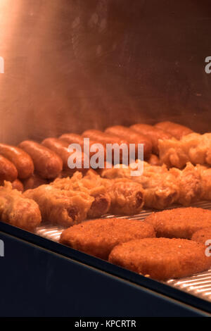 Les aliments frits plaine et saucisses et battues cakes dans un comptoir ou plus chaud en un poisson et chip ou fast food shop à emporter. Les aliments d'engraissement. Banque D'Images