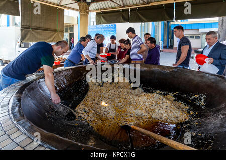 Servir les hommes PLOV (le plat national) à partir d'un grand chaudron au centre de l'Asie centrale plov, Tachkent, Ouzbékistan Banque D'Images