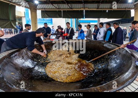 Servir les hommes PLOV (le plat national) à partir d'un grand chaudron au centre de l'Asie centrale plov, Tachkent, Ouzbékistan Banque D'Images