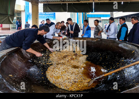 Servir les hommes PLOV (le plat national) à partir d'un grand chaudron au centre de l'Asie centrale plov, Tachkent, Ouzbékistan Banque D'Images